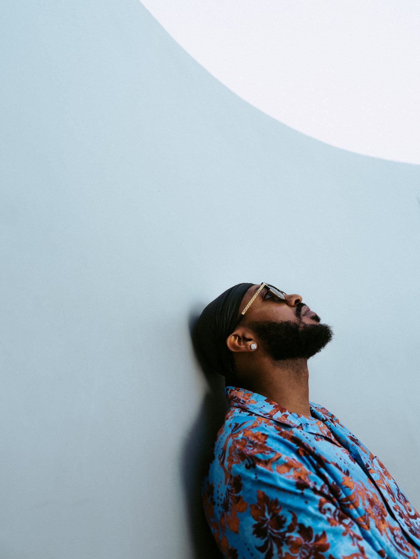 Menasseh against a pale blue wall